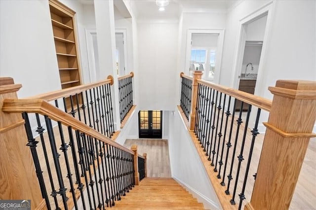 stairs featuring hardwood / wood-style flooring and crown molding