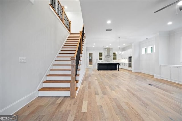 staircase featuring hardwood / wood-style flooring and ceiling fan