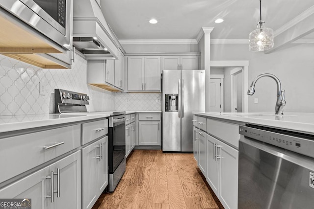 kitchen featuring sink, gray cabinets, stainless steel appliances, ornamental molding, and decorative light fixtures