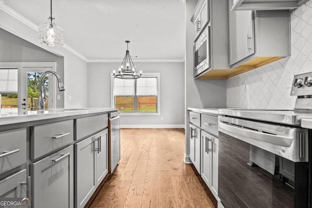 kitchen with stainless steel appliances, decorative light fixtures, and gray cabinetry