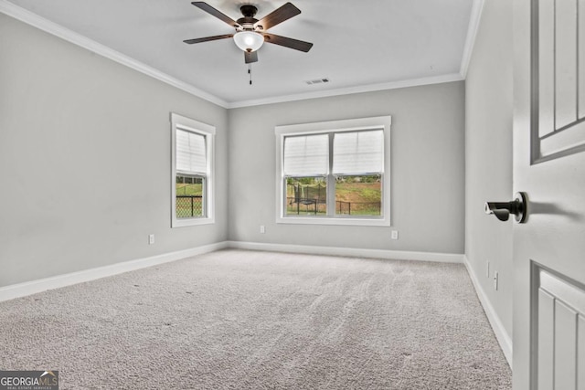 empty room with crown molding, ceiling fan, and carpet floors