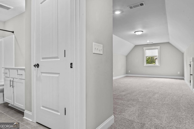 bonus room featuring vaulted ceiling and light colored carpet