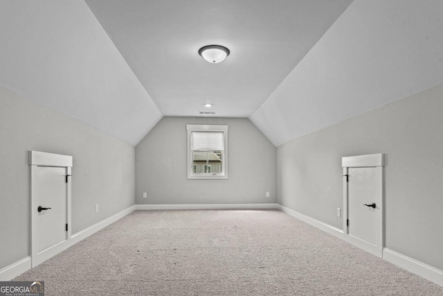 bonus room with lofted ceiling and carpet