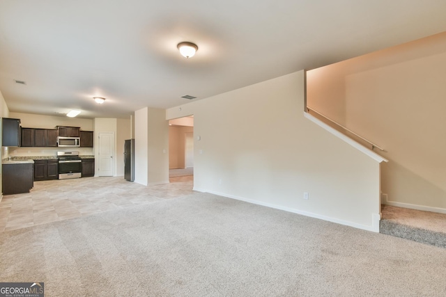 unfurnished living room with light colored carpet