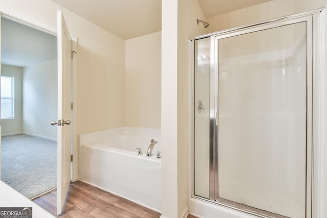 bathroom featuring hardwood / wood-style flooring and shower with separate bathtub