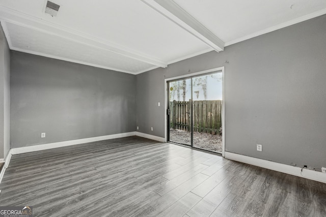 unfurnished room featuring crown molding, dark wood-type flooring, and beam ceiling