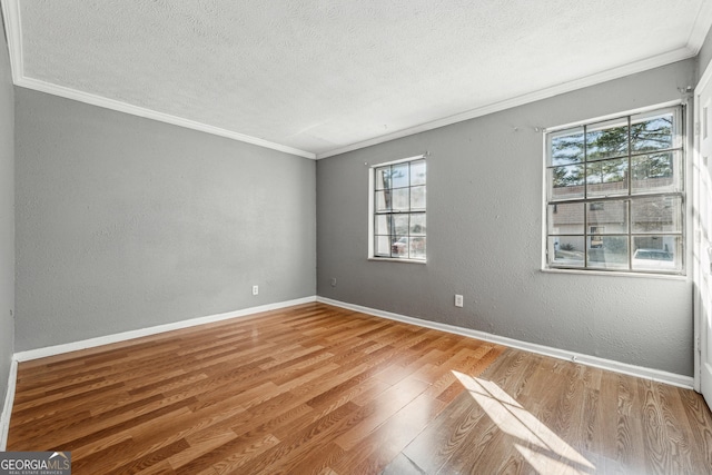 spare room with crown molding, a textured ceiling, and light hardwood / wood-style flooring