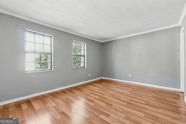 spare room featuring crown molding, light hardwood / wood-style floors, and a textured ceiling