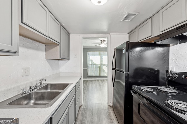 kitchen featuring black electric range oven, sink, light hardwood / wood-style flooring, ceiling fan, and gray cabinetry