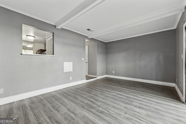 empty room featuring beam ceiling, hardwood / wood-style flooring, and ornamental molding