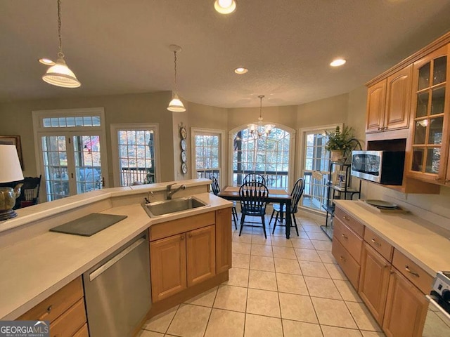 kitchen featuring sink, an inviting chandelier, light tile patterned floors, appliances with stainless steel finishes, and pendant lighting