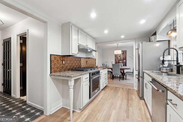 kitchen with white cabinetry, hanging light fixtures, and appliances with stainless steel finishes