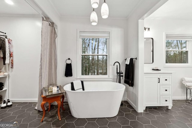 bathroom featuring vanity, a bath, crown molding, and tile patterned flooring