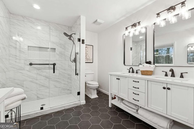 bathroom with tile patterned flooring, vanity, a shower with shower door, and toilet