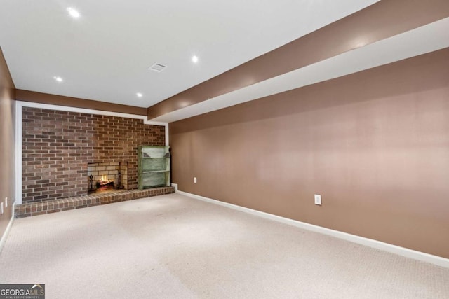 unfurnished living room featuring a brick fireplace and carpet