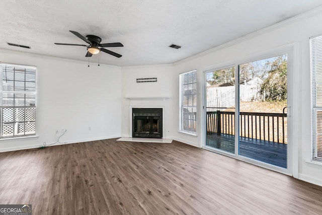 unfurnished living room featuring hardwood / wood-style floors, crown molding, a textured ceiling, and ceiling fan