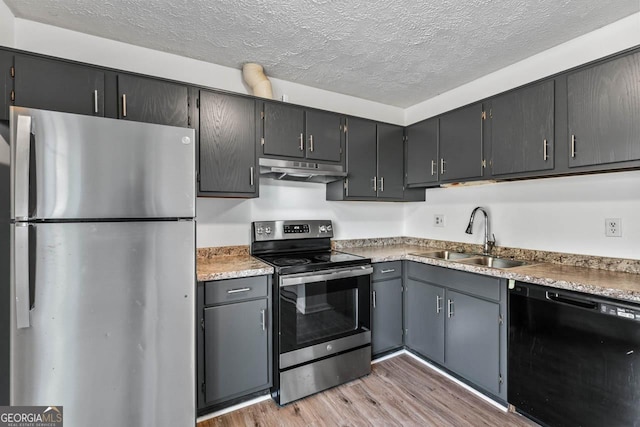 kitchen with sink, light hardwood / wood-style floors, a textured ceiling, and appliances with stainless steel finishes