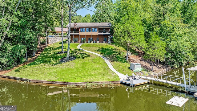 back of house featuring a water view and a yard