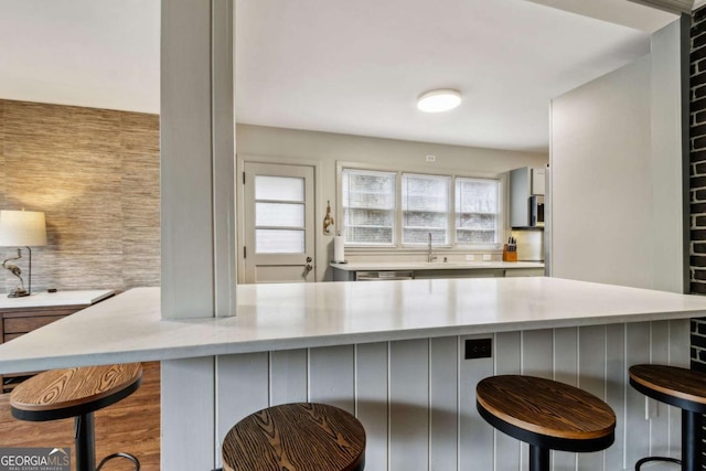 kitchen featuring a healthy amount of sunlight, a kitchen breakfast bar, dishwasher, and decorative backsplash