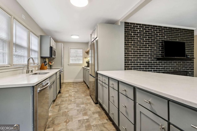 kitchen with sink, gray cabinets, stainless steel appliances, and a healthy amount of sunlight