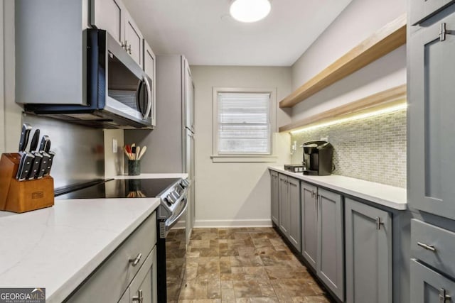 kitchen with gray cabinetry, tasteful backsplash, and appliances with stainless steel finishes