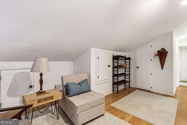 living area featuring lofted ceiling and light wood-type flooring