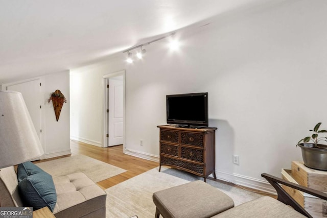 living room with track lighting and light hardwood / wood-style flooring