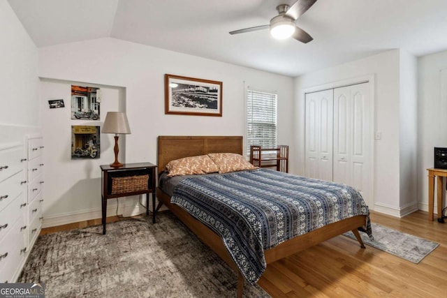 bedroom with lofted ceiling, wood-type flooring, a closet, and ceiling fan