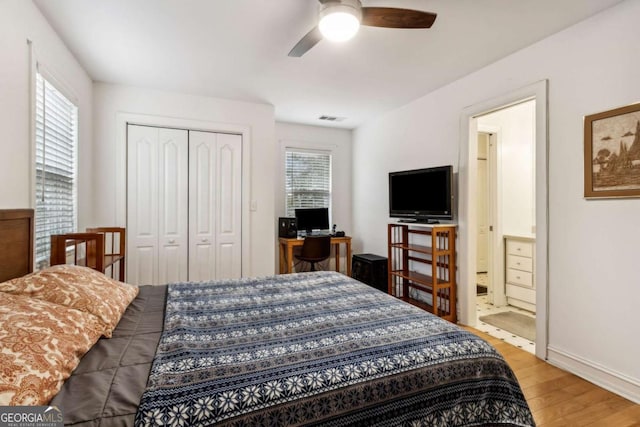 bedroom featuring multiple windows, hardwood / wood-style floors, a closet, and ceiling fan