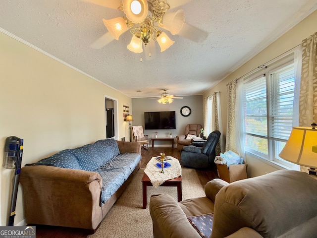 living room with ceiling fan, ornamental molding, a textured ceiling, and light hardwood / wood-style flooring