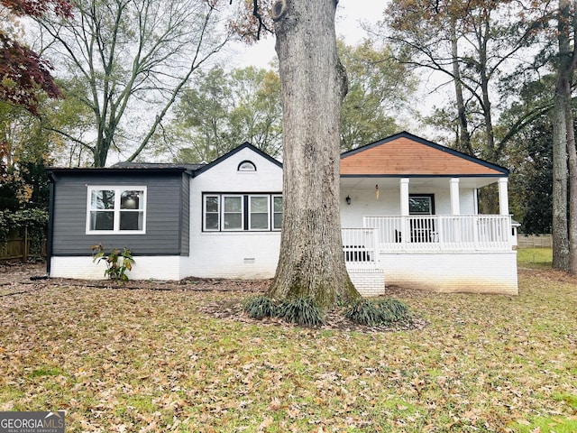 view of front of property featuring covered porch and a front yard