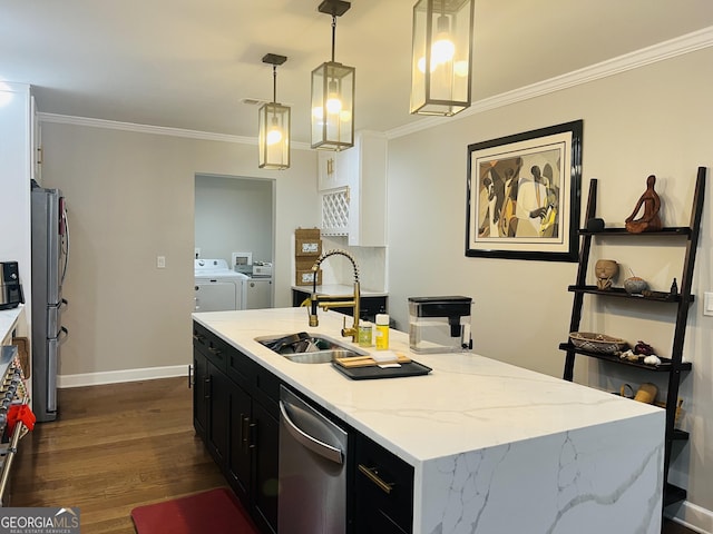 kitchen featuring pendant lighting, sink, crown molding, stainless steel appliances, and washing machine and dryer