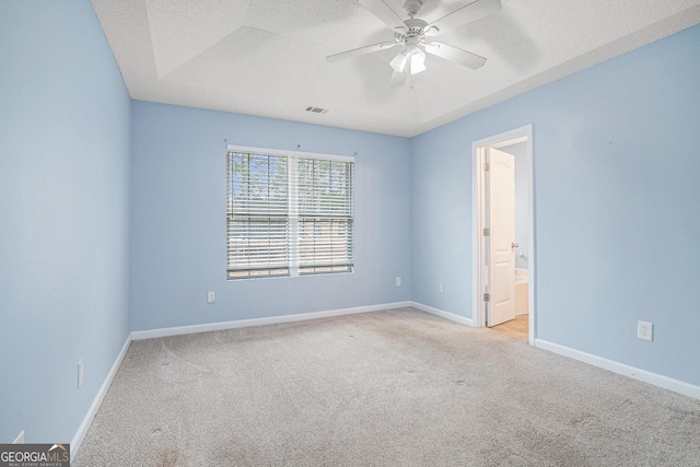 empty room with ceiling fan, light carpet, and a textured ceiling