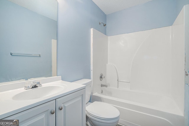 full bathroom with vanity, tub / shower combination, a textured ceiling, and toilet