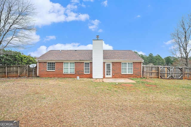 rear view of property with a yard and a patio