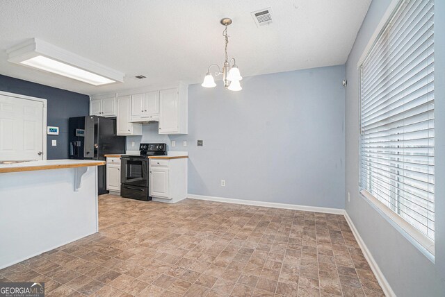 kitchen featuring a kitchen breakfast bar, a notable chandelier, black appliances, white cabinets, and decorative light fixtures