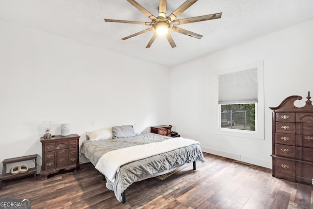 bedroom featuring ceiling fan, hardwood / wood-style flooring, and a textured ceiling