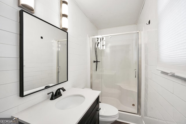 bathroom featuring vanity, toilet, and a shower with door