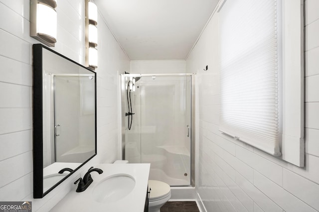 bathroom with sink, a shower with door, and toilet