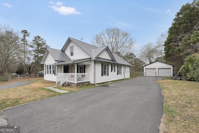 view of front of home with a garage, an outdoor structure, covered porch, and a front lawn