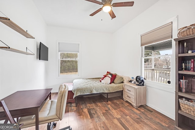 bedroom featuring multiple windows, dark wood-type flooring, and ceiling fan