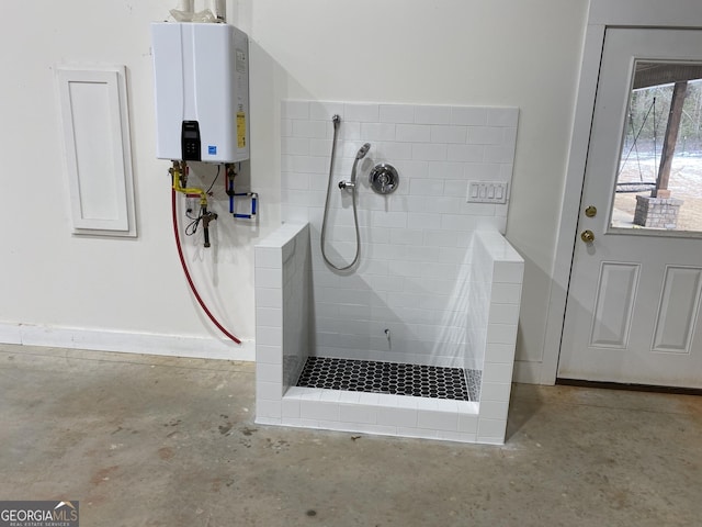 bathroom with concrete floors, tankless water heater, and tiled shower