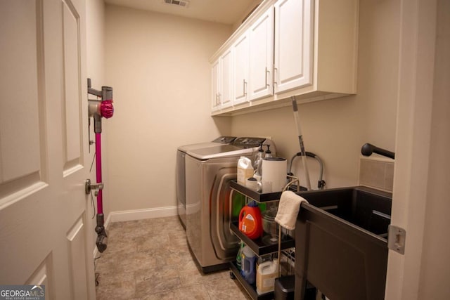 laundry room with cabinets and washer and clothes dryer