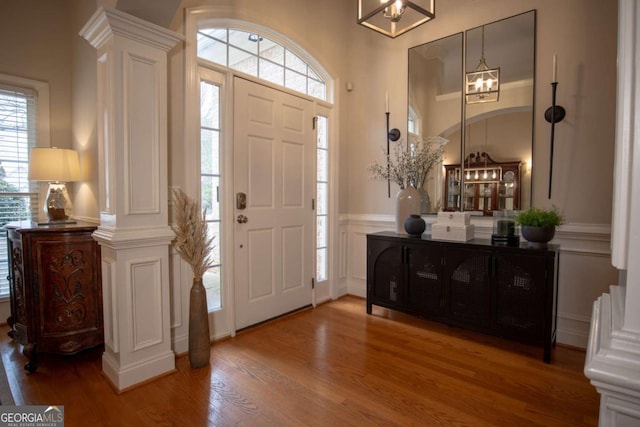 foyer entrance featuring ornate columns and hardwood / wood-style floors