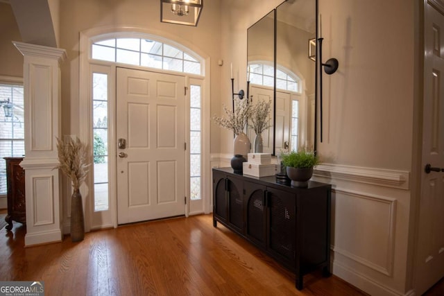 foyer featuring decorative columns and hardwood / wood-style floors