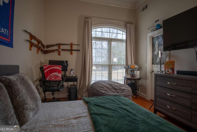 bedroom featuring hardwood / wood-style floors and crown molding