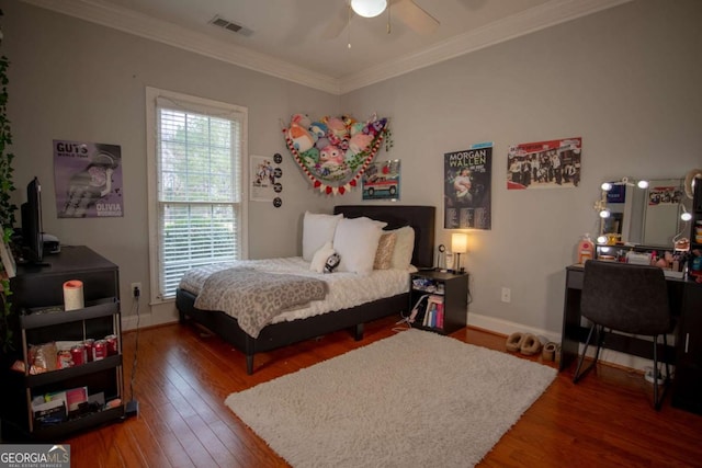 bedroom with crown molding, dark hardwood / wood-style floors, and ceiling fan