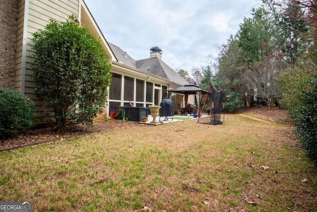 view of yard featuring a gazebo and a sunroom