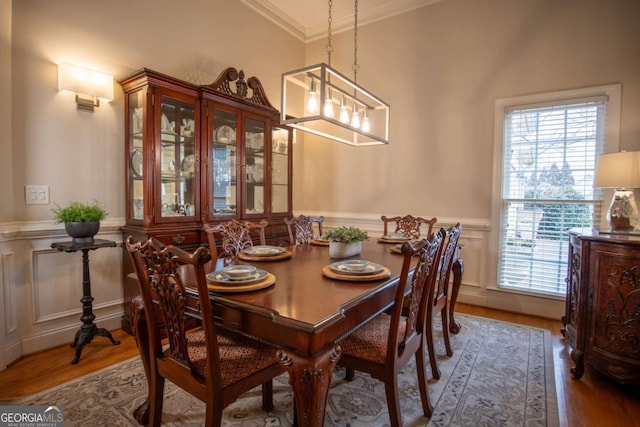 dining area featuring wood-type flooring and ornamental molding