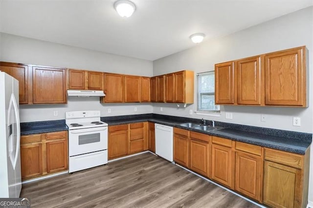 kitchen with sink, white appliances, and dark wood-type flooring